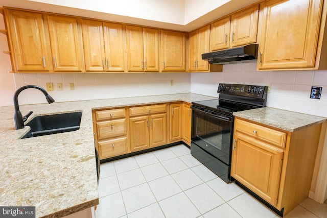 kitchen featuring tasteful backsplash, sink, light stone counters, and black range with electric cooktop