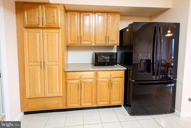 kitchen featuring tasteful backsplash, light tile patterned floors, and black refrigerator with ice dispenser