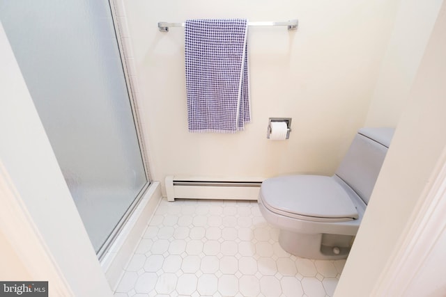 bathroom with a shower with shower door, toilet, and baseboard heating