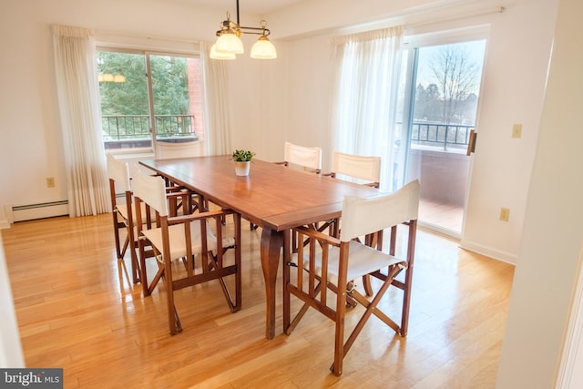 dining space featuring a baseboard heating unit and light wood-type flooring