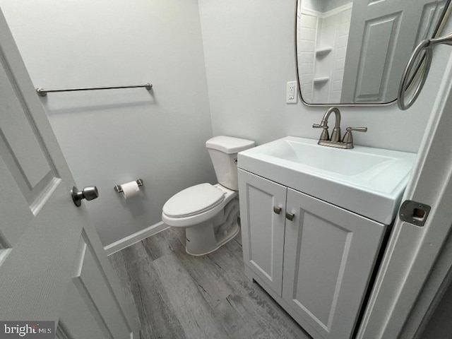 bathroom with hardwood / wood-style floors, vanity, and toilet