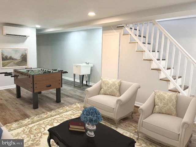 game room with an AC wall unit and hardwood / wood-style flooring