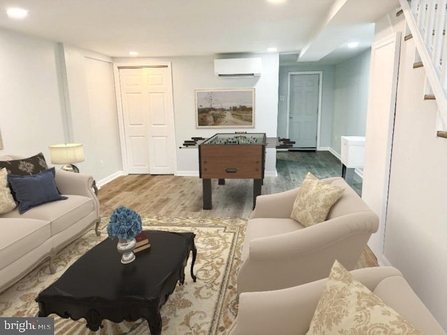 recreation room featuring a wall mounted air conditioner and hardwood / wood-style floors