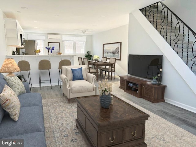 living room with hardwood / wood-style flooring, ceiling fan, and a wall mounted AC