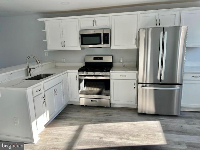 kitchen with sink, white cabinets, and stainless steel appliances