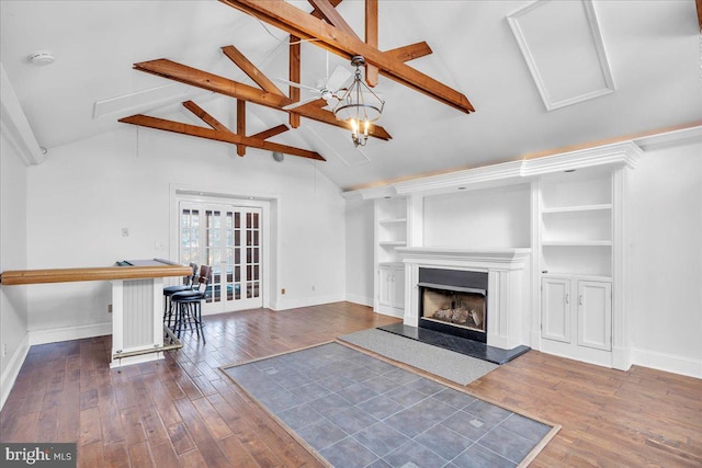 unfurnished living room with vaulted ceiling with beams, dark wood-type flooring, and french doors