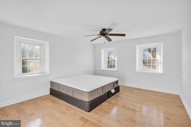 unfurnished bedroom featuring light wood-type flooring and ceiling fan