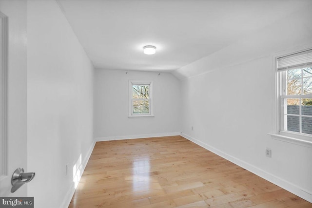 additional living space featuring lofted ceiling and light hardwood / wood-style flooring