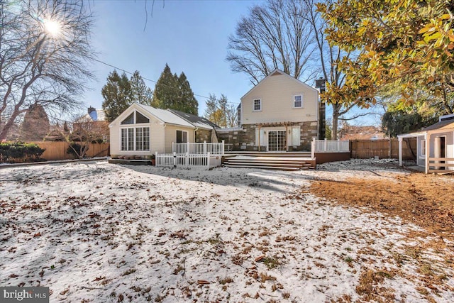 snow covered house featuring a deck