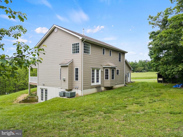 rear view of house with a yard and central air condition unit