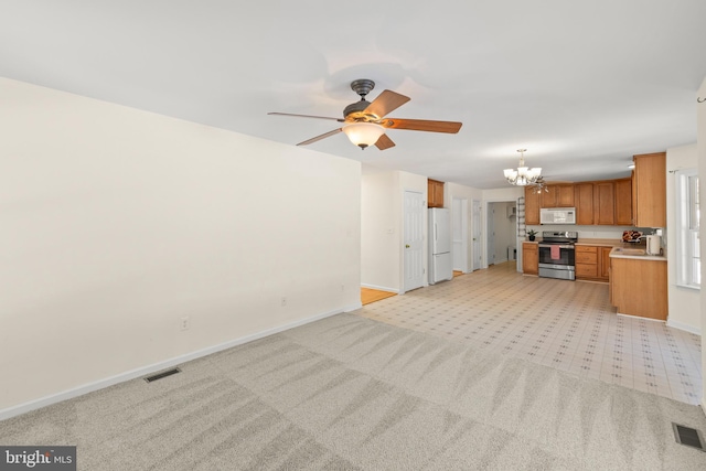 unfurnished living room with light carpet and ceiling fan with notable chandelier