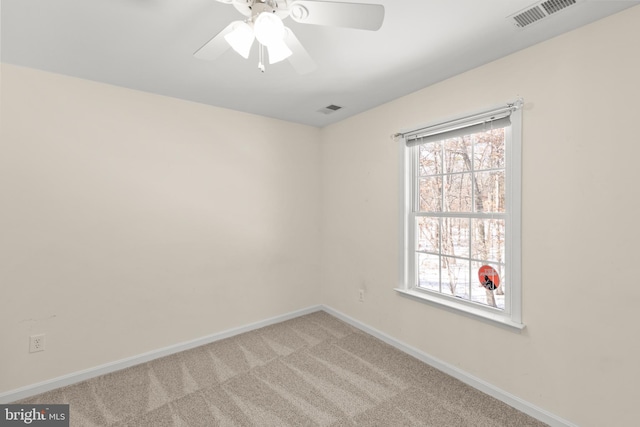 carpeted spare room with ceiling fan