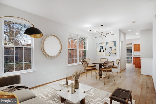 living room with light hardwood / wood-style flooring and a notable chandelier