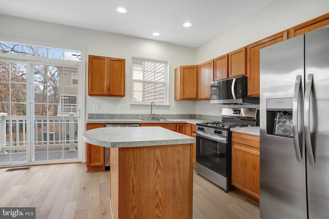 kitchen featuring a center island, sink, light wood-type flooring, and stainless steel appliances