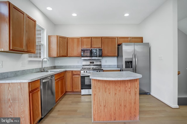 kitchen with light wood-type flooring, a center island, stainless steel appliances, and sink