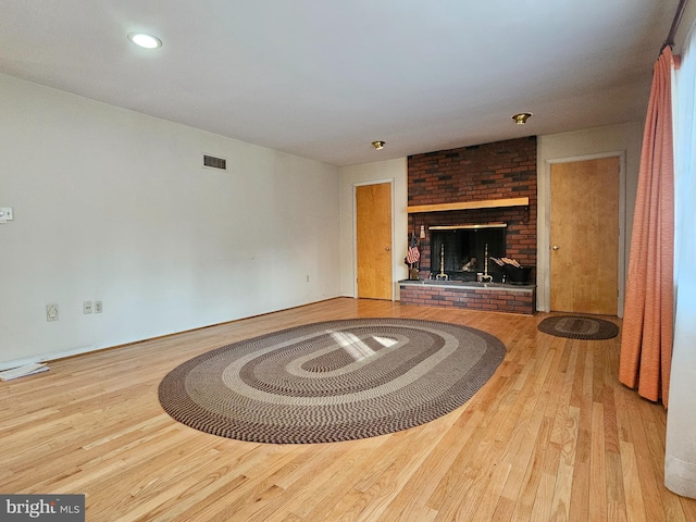 unfurnished living room with a fireplace and light wood-type flooring