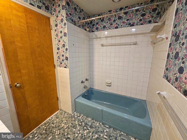 bathroom featuring tile patterned floors, tile walls, and tiled shower / bath