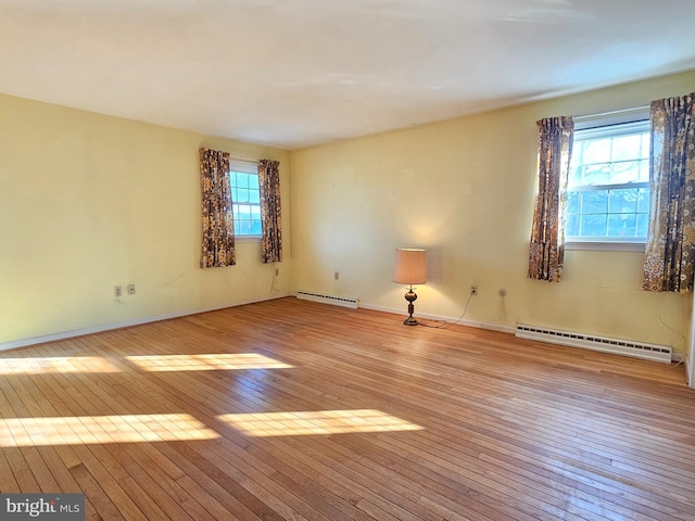 spare room featuring light wood-type flooring and a baseboard heating unit