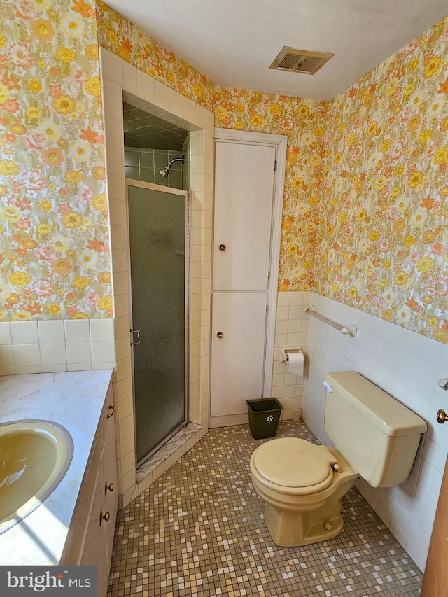 bathroom with tile patterned floors, vanity, toilet, and walk in shower