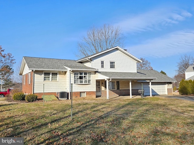 view of front of property featuring cooling unit, a garage, and a front yard