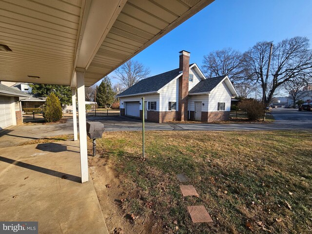 view of yard with an outbuilding, a garage, and a carport