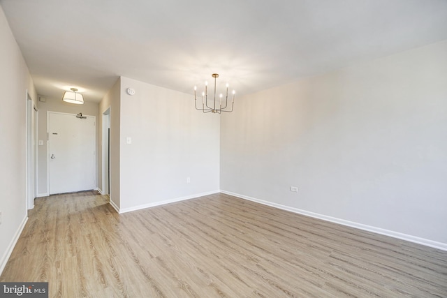 unfurnished room featuring light hardwood / wood-style flooring and a chandelier