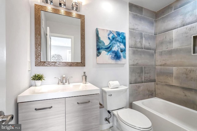 full bathroom with tiled shower / bath, vanity, and toilet