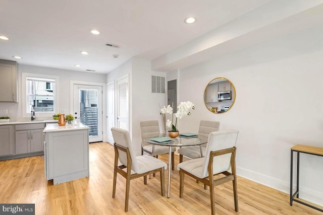 dining room with sink and light wood-type flooring