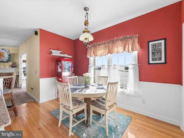 dining space with wainscoting and hardwood / wood-style flooring