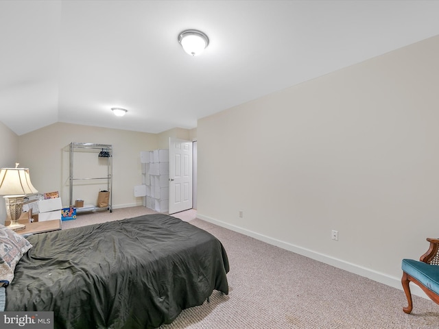 carpeted bedroom with vaulted ceiling and baseboards