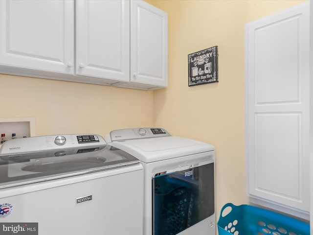 clothes washing area with washer and clothes dryer and cabinet space