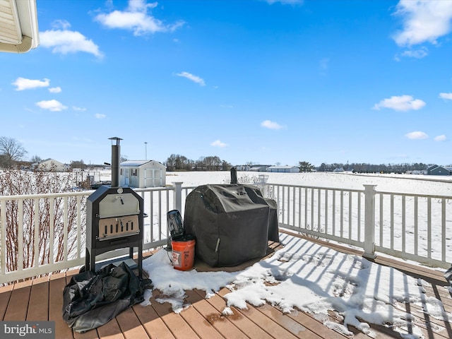 snow covered deck with an outbuilding and a grill