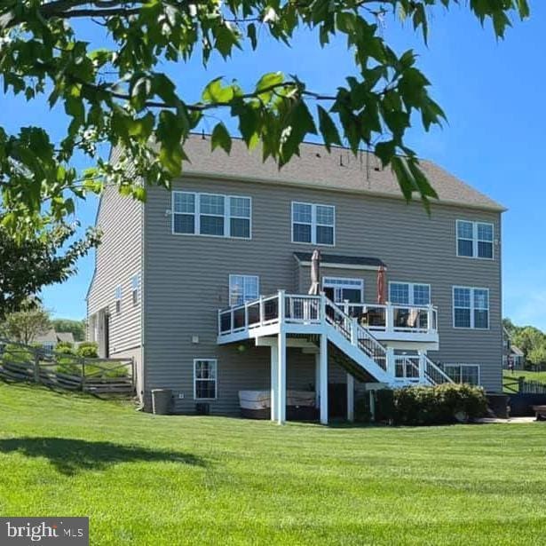 rear view of property with a lawn and a wooden deck