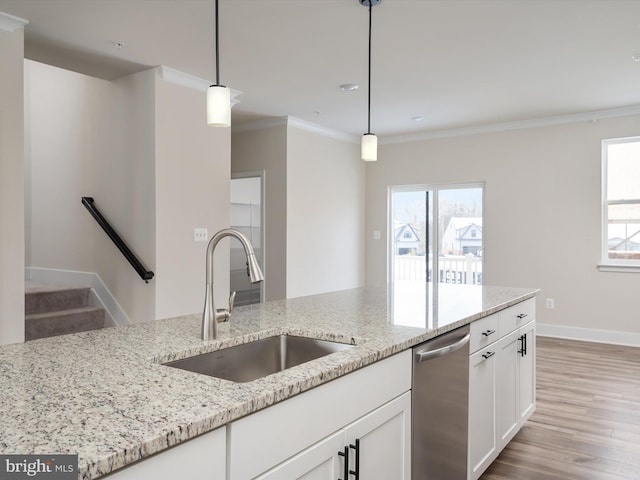 kitchen with dishwasher, crown molding, light stone counters, sink, and decorative light fixtures