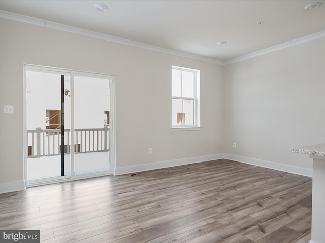 spare room featuring light wood-type flooring and ornamental molding