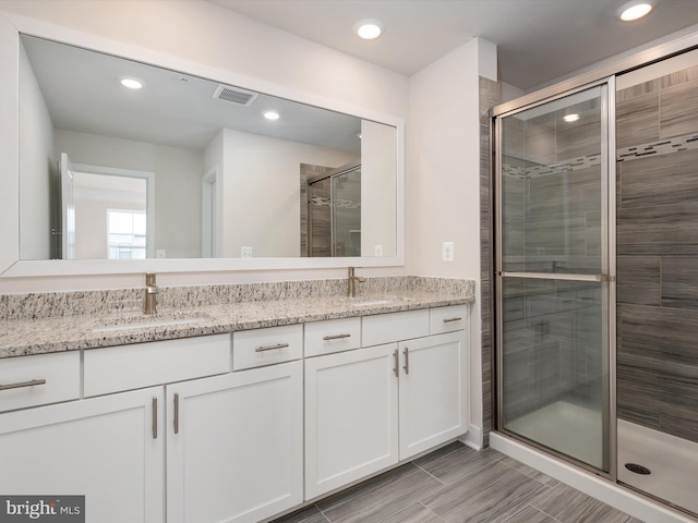 bathroom featuring an enclosed shower and vanity