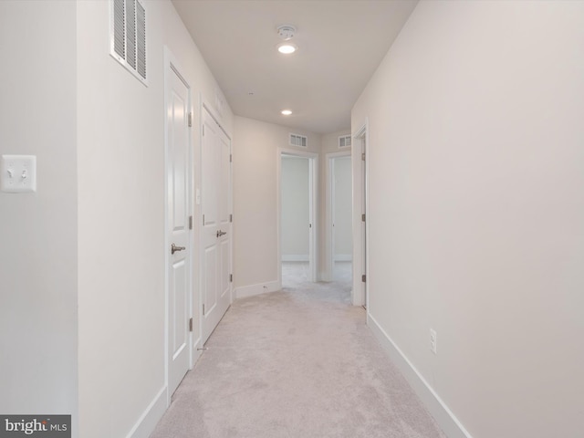 hallway featuring light colored carpet