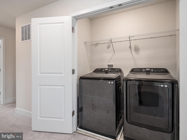 laundry room featuring washing machine and dryer and light carpet