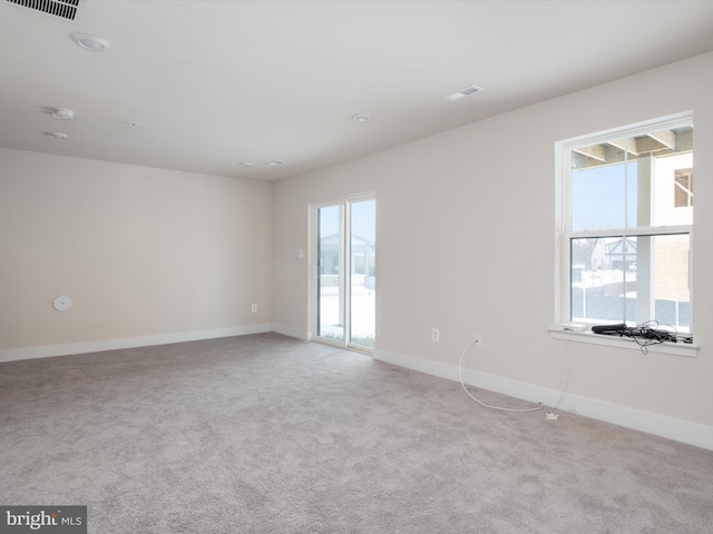 carpeted spare room with a healthy amount of sunlight