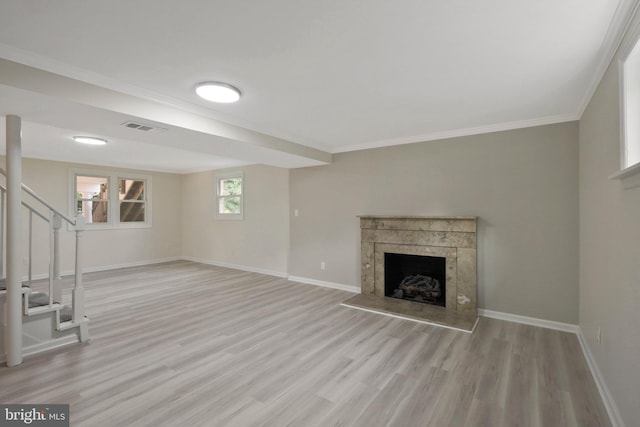 unfurnished living room with ornamental molding and light wood-type flooring