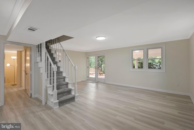 basement featuring french doors and light wood-type flooring