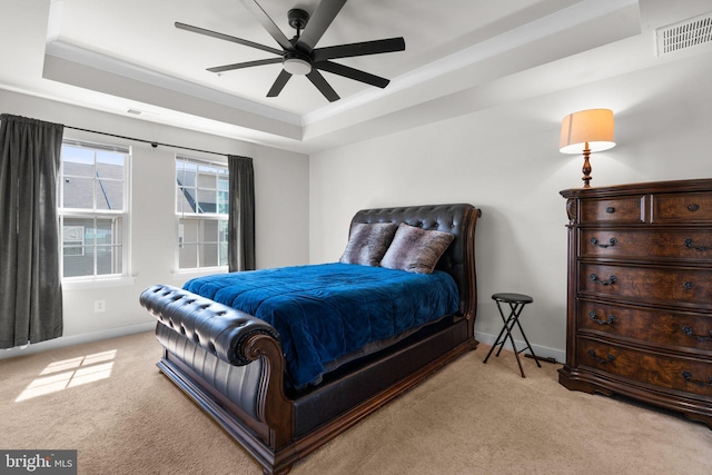 carpeted bedroom with a raised ceiling, ceiling fan, and crown molding