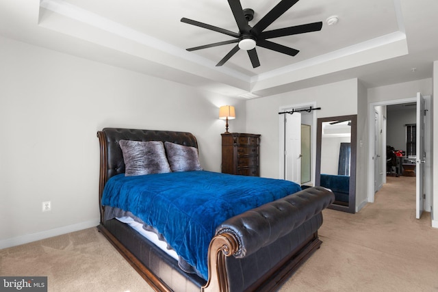 carpeted bedroom with a tray ceiling and ceiling fan