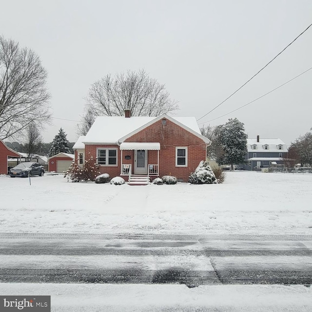 view of front of house featuring a garage and an outbuilding