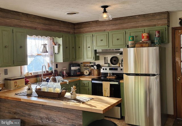 kitchen featuring wooden counters, kitchen peninsula, a textured ceiling, appliances with stainless steel finishes, and green cabinetry