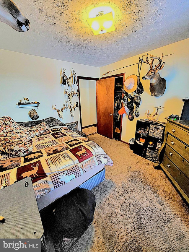 carpeted bedroom featuring a textured ceiling and a closet