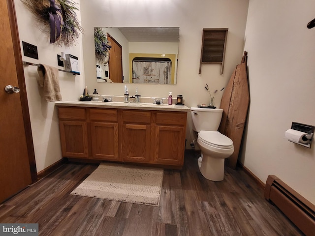 bathroom featuring hardwood / wood-style flooring, toilet, vanity, and a baseboard heating unit