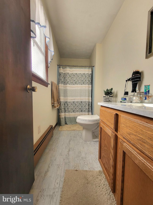 bathroom featuring baseboard heating, hardwood / wood-style floors, vanity, and toilet