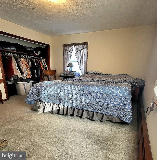 carpeted bedroom with a textured ceiling and a closet