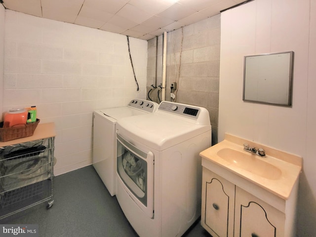 clothes washing area with separate washer and dryer and sink